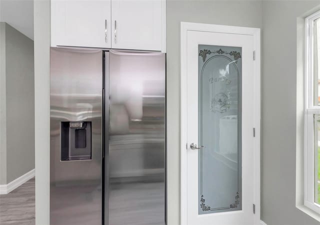 8505 N Brooks St, Tampa, FL 33604 - kitchen featuring stainless steel fridge with ice dispenser, white cabinets, wood finished floors, and baseboards