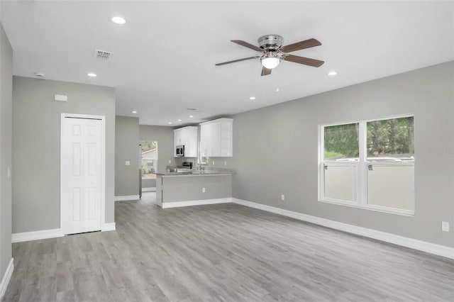 8505 N Brooks St, Tampa, FL 33604 - unfurnished living room featuring a ceiling fan, light wood-style flooring, baseboards, recessed lighting, and a sink