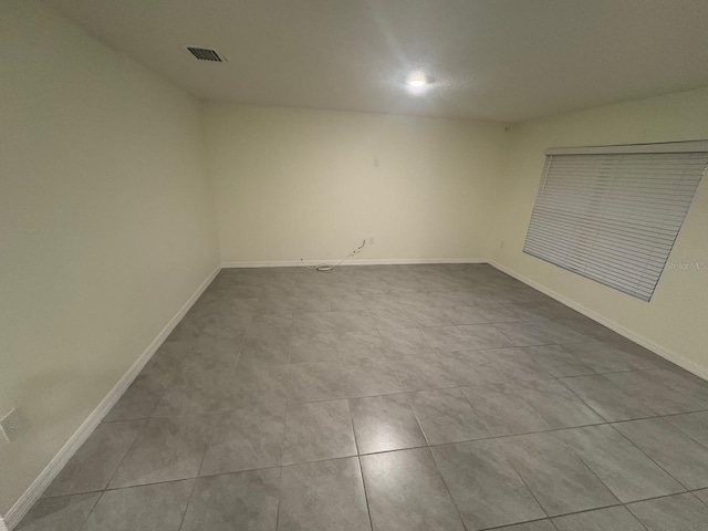 unfurnished room with baseboards, visible vents, and tile patterned floors