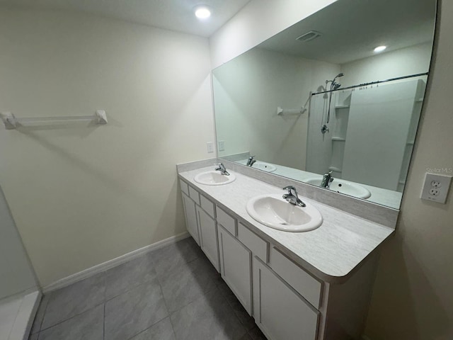 bathroom featuring baseboards, double vanity, and a sink