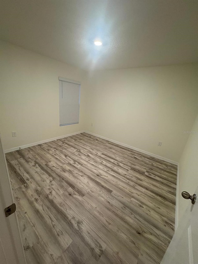 unfurnished room featuring baseboards and wood finished floors