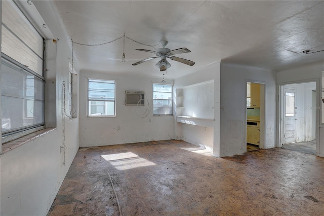 unfurnished room with ceiling fan and a wall mounted AC