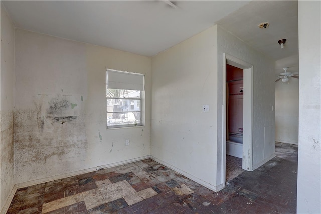 unfurnished room featuring baseboards and ceiling fan