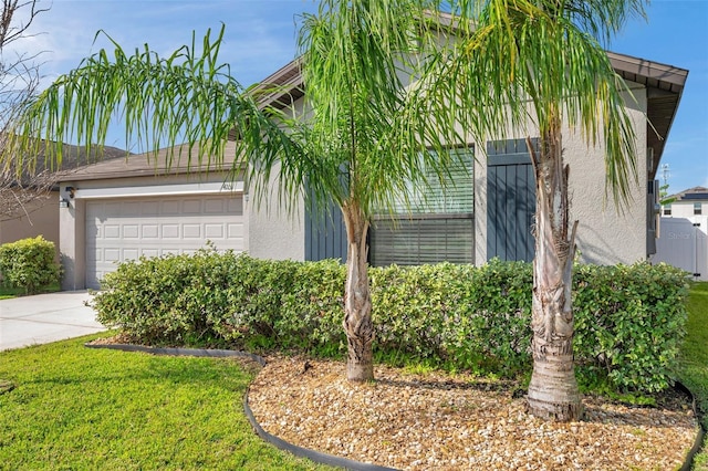 4201 Globe Thistle Dr, Tampa, FL 33619 - view of home's exterior featuring an attached garage, concrete driveway, and stucco siding