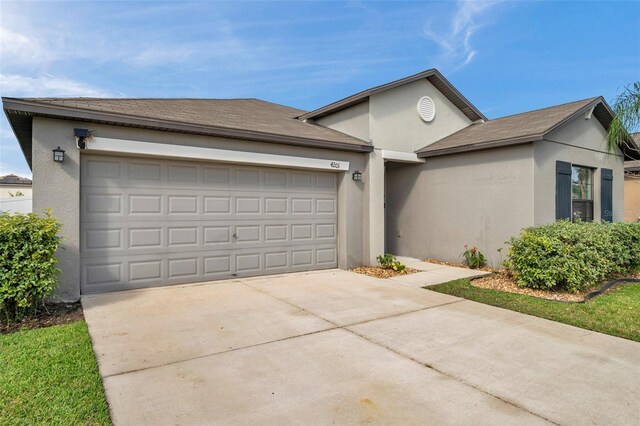 4201 Globe Thistle Dr, Tampa, FL 33619 - view of front of home with concrete driveway, a garage, and stucco siding