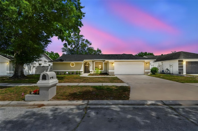 ranch-style house with stucco siding, an attached garage, and concrete driveway