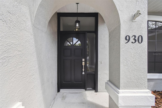 entrance to property featuring stucco siding