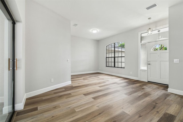 foyer entrance with baseboards, visible vents, and light wood-type flooring
