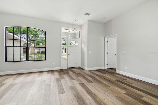foyer with visible vents, baseboards, and wood finished floors
