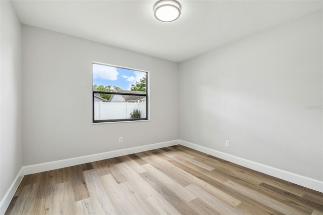 unfurnished room with baseboards and light wood finished floors