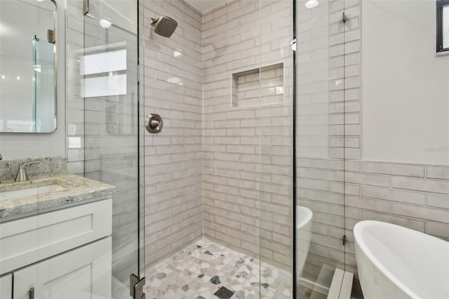 full bath featuring vanity, tile walls, a shower stall, and a freestanding bath