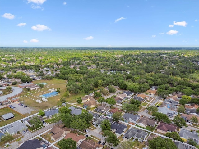 drone / aerial view with a wooded view and a residential view