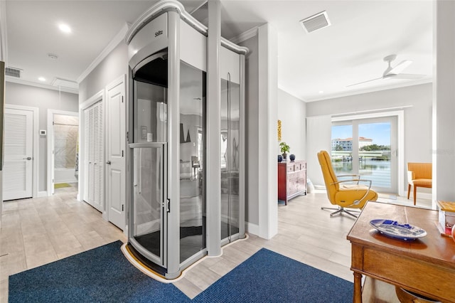interior space with baseboards, ornamental molding, visible vents, and a ceiling fan