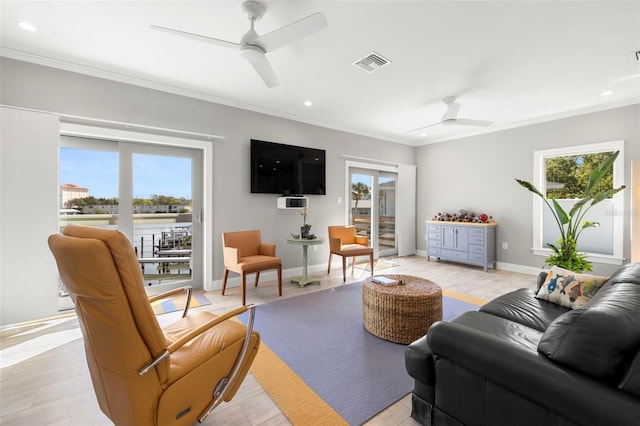 living room featuring a wealth of natural light, visible vents, and a ceiling fan