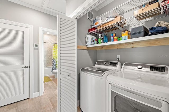 washroom with laundry area, light wood-style floors, attic access, and separate washer and dryer