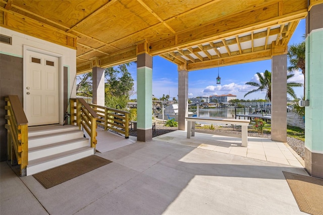 view of patio with a water view and visible vents