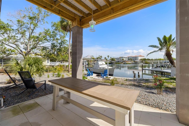 view of patio / terrace featuring boat lift, a dock, and a water view