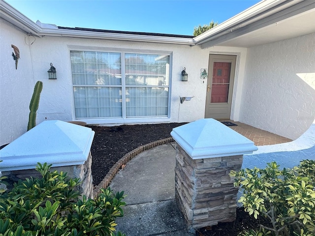 view of exterior entry with stucco siding