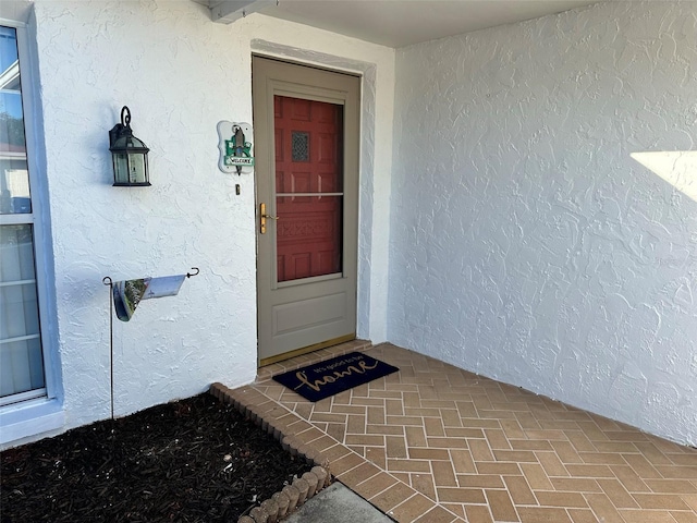 doorway to property featuring stucco siding