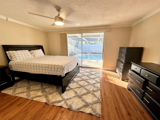 bedroom with access to exterior, wood finished floors, ceiling fan, and ornamental molding