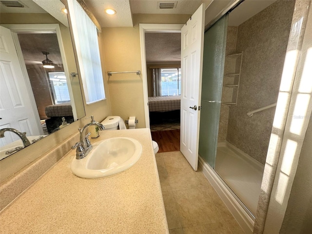 ensuite bathroom featuring connected bathroom, a stall shower, toilet, vanity, and visible vents