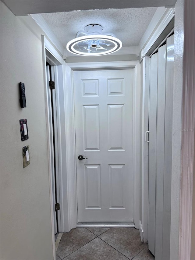 corridor featuring light tile patterned floors and a textured ceiling
