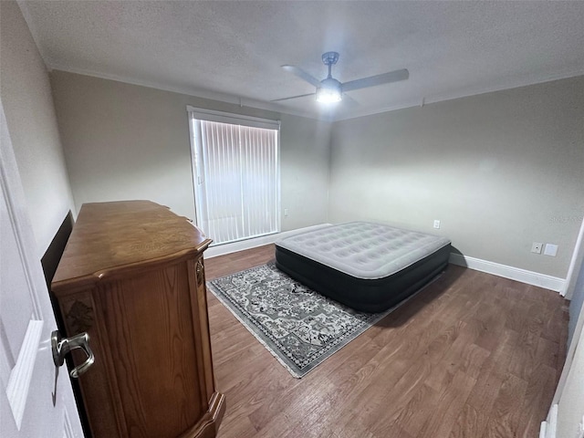 bedroom with baseboards, a ceiling fan, wood finished floors, and a textured ceiling