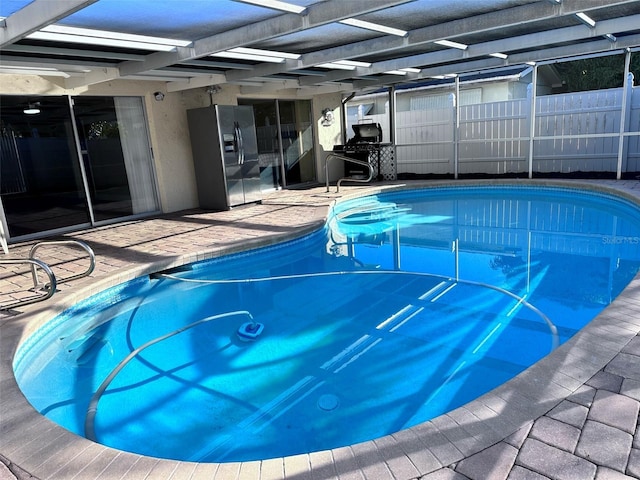 view of swimming pool featuring a fenced in pool, glass enclosure, fence, and a patio