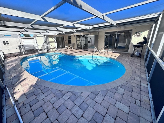 pool with glass enclosure and a patio area