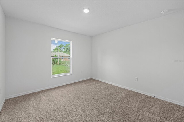 carpeted empty room with baseboards