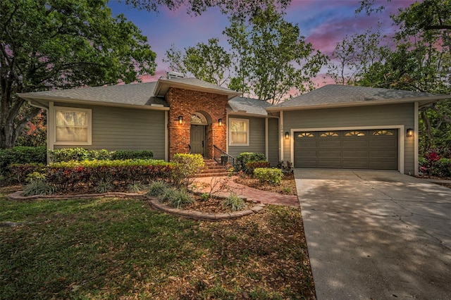 2997 Eagle Estates Cir E, Clearwater, FL 33761 - ranch-style home with roof with shingles, a garage, concrete driveway, and brick siding