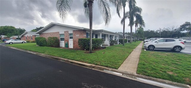 605 Brandy Wine Dr Unit 605, Largo, FL 33771 - view of home's exterior featuring a lawn, brick siding, and a residential view