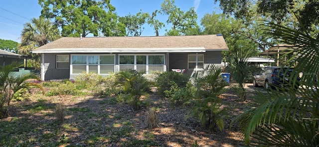 rear view of property featuring roof with shingles