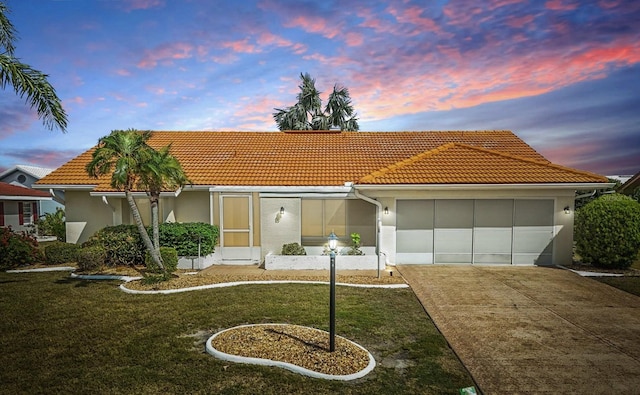 1805 Granville Ln, Sun City Center, FL 33573 - mediterranean / spanish-style home featuring concrete driveway, a tile roof, a garage, and stucco siding