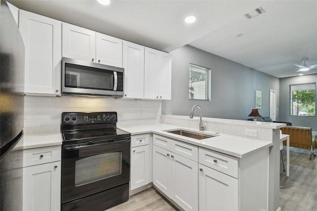 3411 N 12th St, Tampa, FL 33605 - kitchen featuring light countertops, stainless steel appliances, a sink, visible vents, and a peninsula