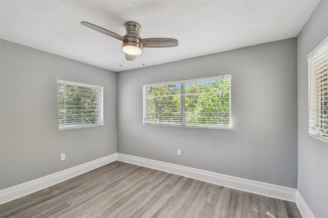 3411 N 12th St, Tampa, FL 33605 - empty room with a ceiling fan, a textured ceiling, baseboards, and wood finished floors