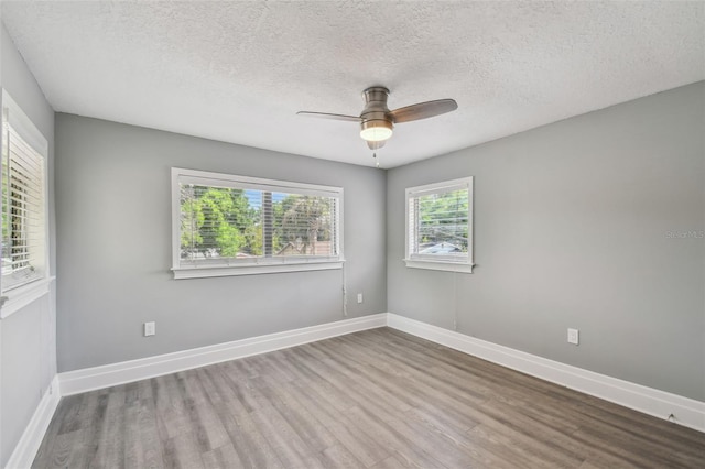 3411 N 12th St, Tampa, FL 33605 - spare room featuring baseboards, a textured ceiling, wood finished floors, and a ceiling fan