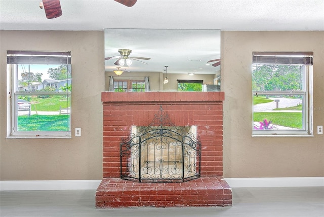 room details featuring wood finished floors, a fireplace, a ceiling fan, and baseboards