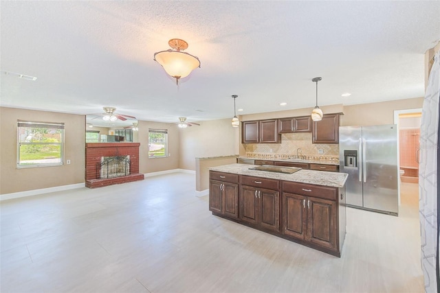 kitchen featuring backsplash, a ceiling fan, stainless steel fridge, and plenty of natural light