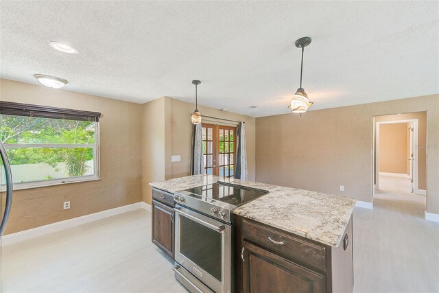 kitchen featuring hanging light fixtures, stainless steel range, dark brown cabinetry, a textured ceiling, and french doors