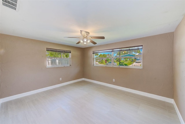 empty room featuring visible vents, baseboards, and a ceiling fan