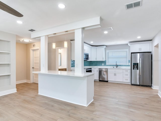 kitchen with white cabinetry, a sink, appliances with stainless steel finishes, and visible vents