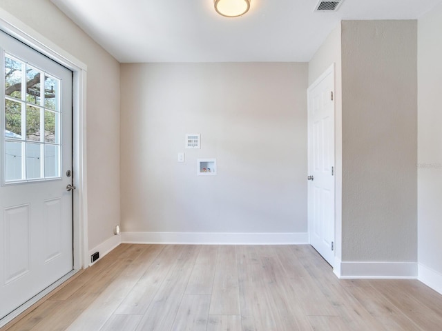 clothes washing area featuring washer hookup, baseboards, laundry area, and light wood-style floors