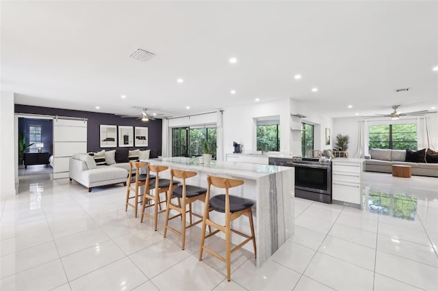 kitchen with open floor plan, electric range, ceiling fan, and visible vents