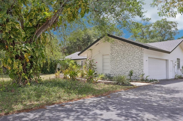 view of home's exterior featuring stucco siding, a garage, and aphalt driveway