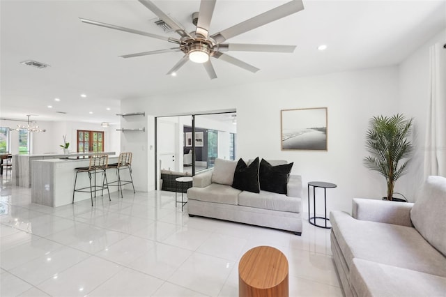 living room with visible vents, recessed lighting, light tile patterned floors, and ceiling fan with notable chandelier