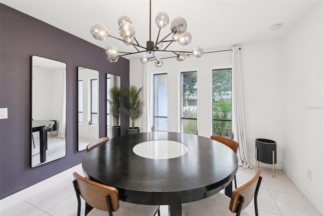 dining room featuring light tile patterned floors, baseboards, and a notable chandelier