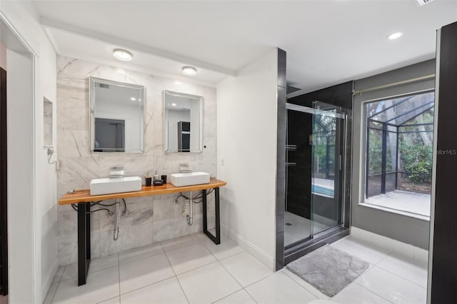 full bathroom featuring a sink, tile patterned flooring, a shower stall, and double vanity