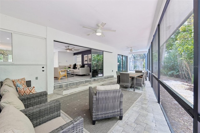 sunroom with outdoor lounge area, outdoor dining space, and a ceiling fan