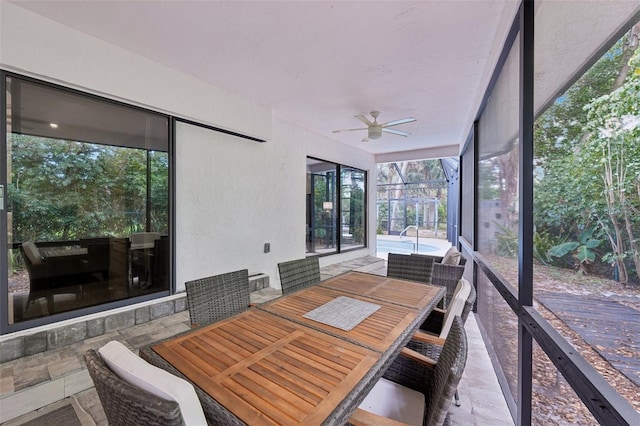 sunroom / solarium with ceiling fan and outdoor dining area